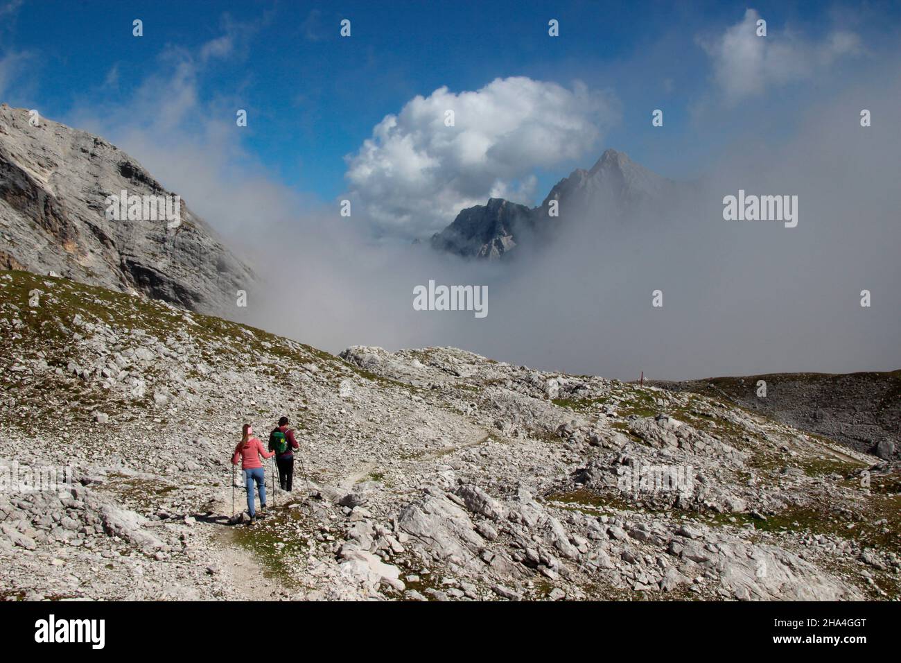 jeune couple randonnée,descente du zugspitze,wetterstein montagnes bleu ciel,nuages,nuage humeur,derrière lui le sommet de hochwanner 2744m,garmisch-partenkirchen,loisachtal,haute-bavière,bavière,sud allemagne,allemagne,europe, Banque D'Images