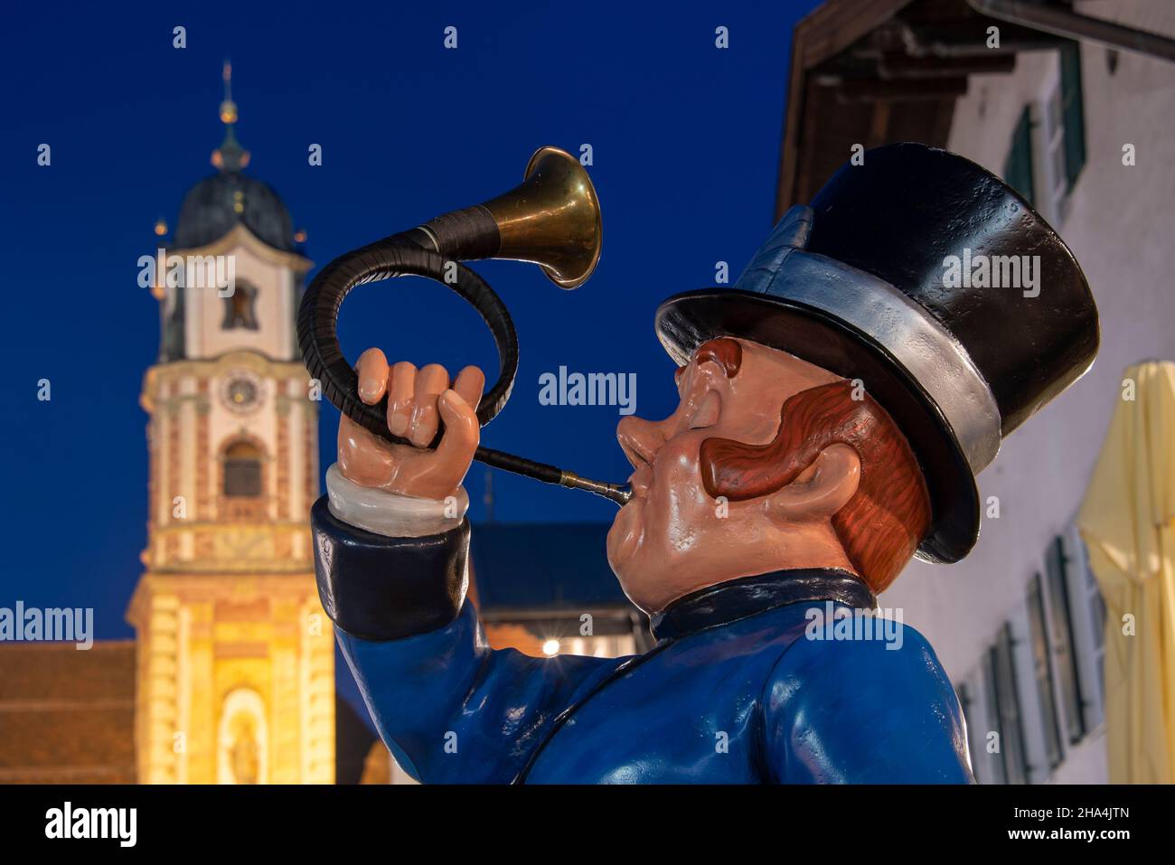 chasse des souffleurs de corne, entrée au posthotel, derrière lui l'église de st. pierre et paul à l'heure bleue, obermarkt, mittenwald, haute-bavière, bavière, allemagne Banque D'Images