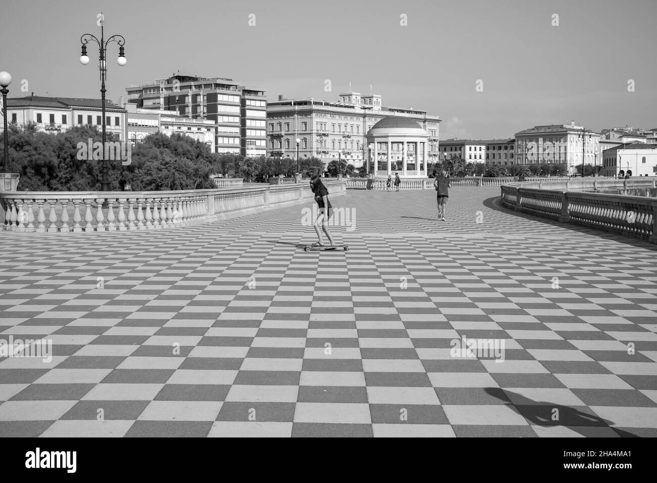 skater fille de patinage et de saut sur terrazza mascagni à livourne, en italie. son grand belvédère sinueux vers la mer avec une surface pavée de 8700 m² comme un damier et 4,100 balusters Banque D'Images