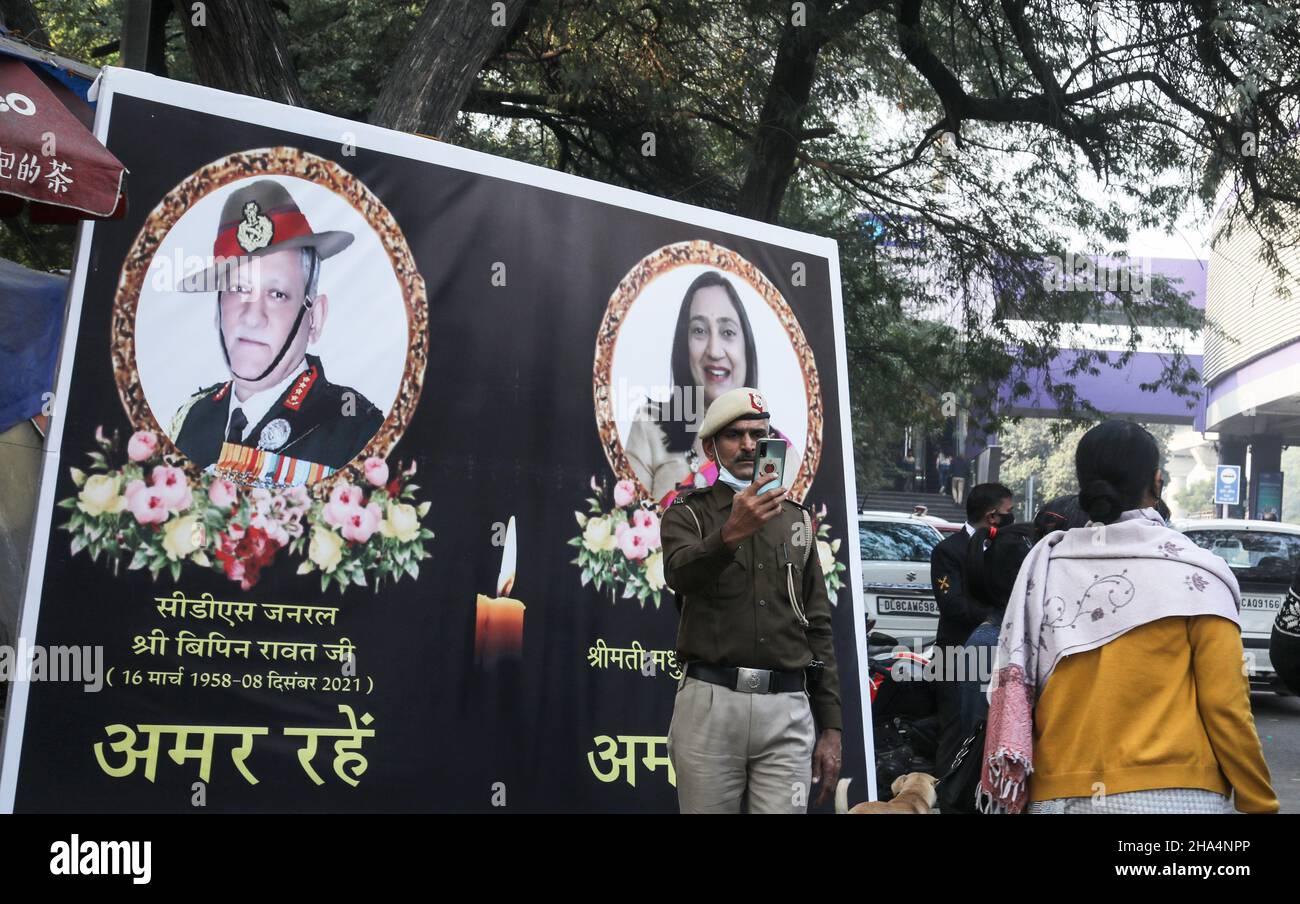 New Delhi, Inde.10th décembre 2021.Un membre de la police de Delhi prend un selfie devant l'affiche du Chef d'état-major de la Défense (CEMD) pendant le cortège funéraire.Le général Bipin Rawat, son épouse Madhulika et 11 autres membres des forces armées ont perdu la vie dans un accident mi-17V5 de l'Aviation indienne à Coonoor, au Tamil Nadu.CDS Bipin Rawat a été incinéré avec des honneurs militaires à la place Bar à Delhi Cantonmet.Crédit : SOPA Images Limited/Alamy Live News Banque D'Images