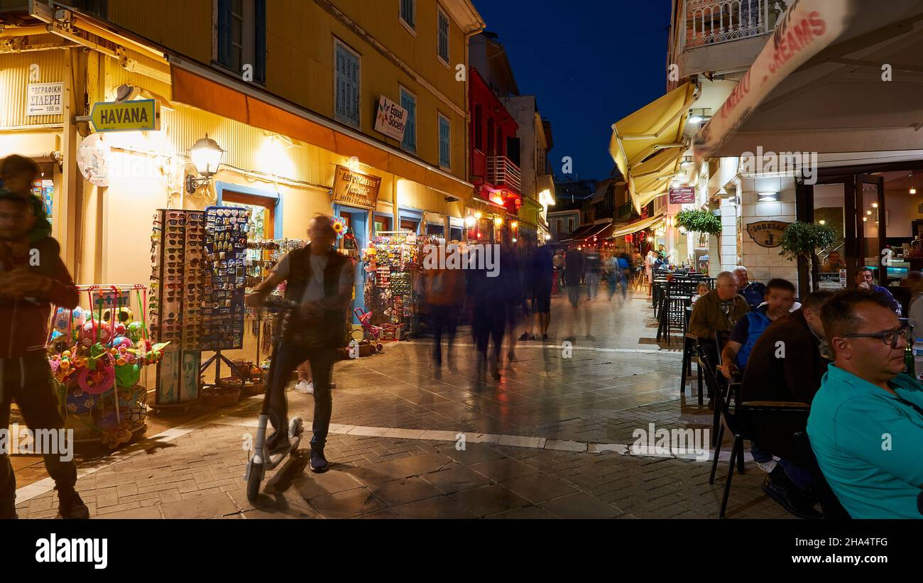 grèce,iles grecques,iles ioniennes,lefkada ou lefkas,ville de lefkada,capitale,humeur du soir,zone piétonne,longue exposition,personnes floues,homme sur scooter,éclairage artificiel de rue Banque D'Images