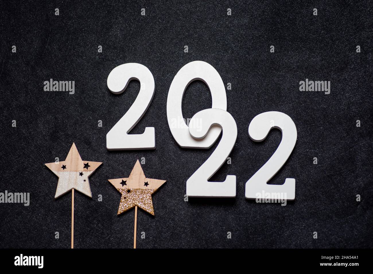 Panneau du nouvel an 2022 en bois sur fond festif avec espace pour les copies.Le bois peint en blanc a créé l'inscription numéro 2022 sur fond noir. Banque D'Images