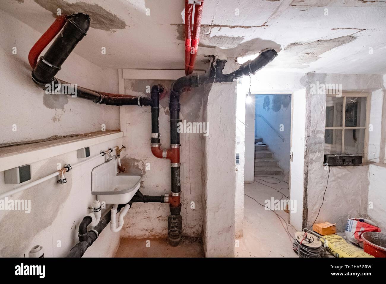 chantier de construction, réaménagement et rénovation d'un appartement, chambre vide d'une buanderie dans le sous-sol avec de vieux tuyaux d'égout Banque D'Images
