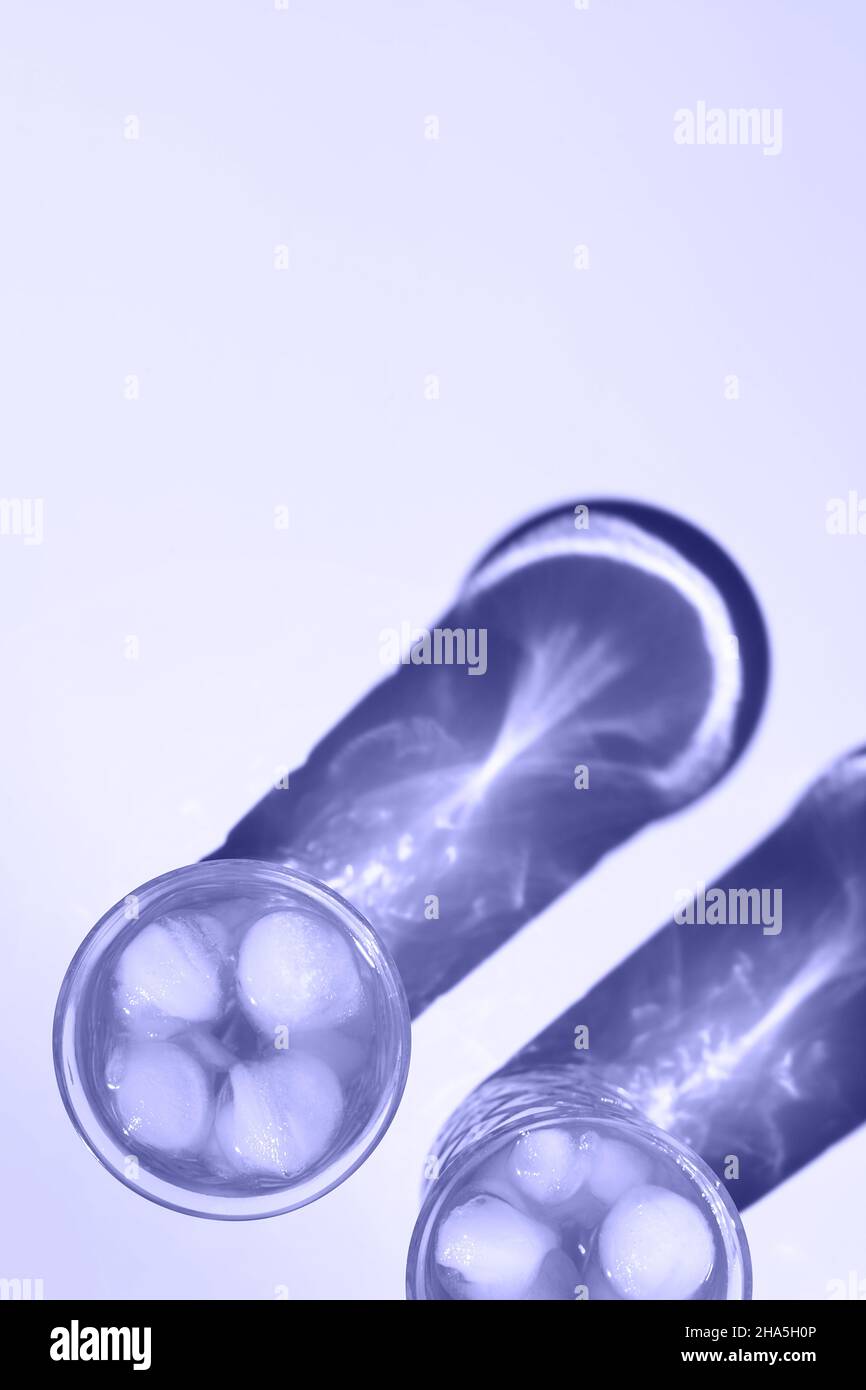 Deux magnifiques verres en cristal jettent de longues ombres de la lumière du soleil.Coloris tendance de l'année 2022.Composition créative minimale dans un style de pose à plat avec espace de copie.Concept des boissons d'été. Banque D'Images
