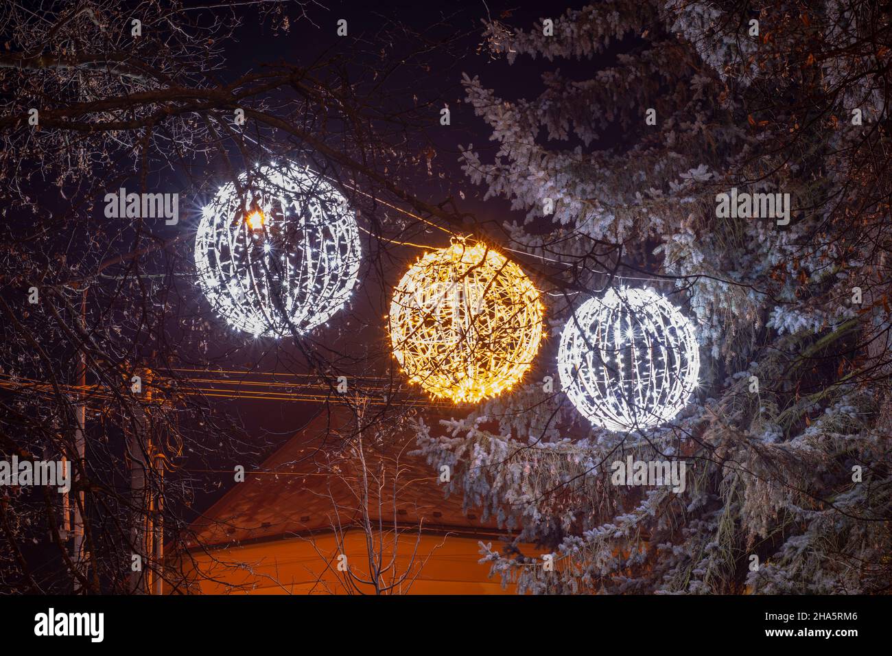 BOULES LUMINEUSES DE Noël À DEL suspendues à l'arbre en hiver.Décoration sphères lumineuses. Banque D'Images