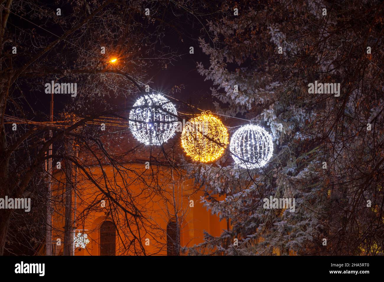 BOULES LUMINEUSES DE Noël À DEL suspendues à l'arbre en hiver.Décoration sphères lumineuses. Banque D'Images