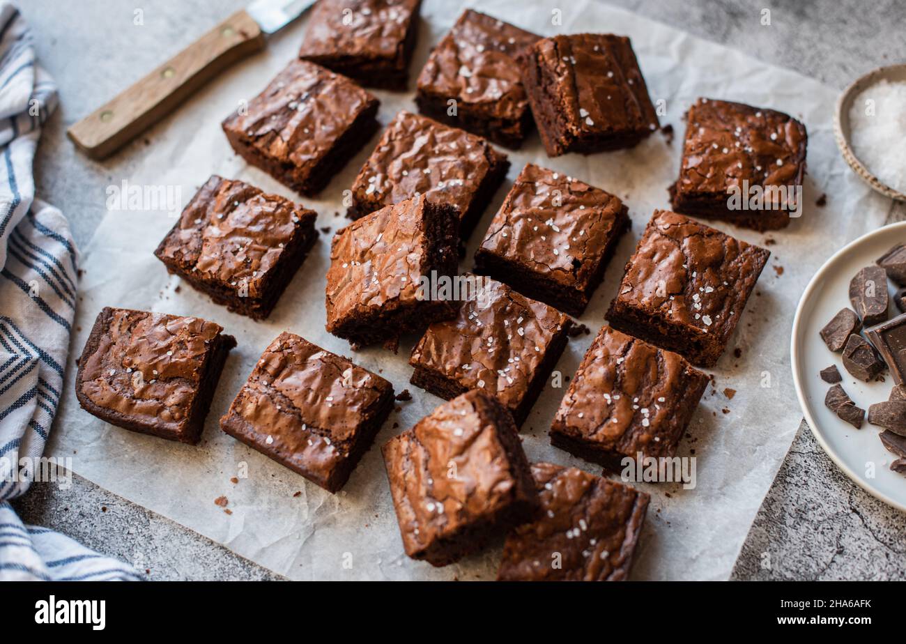 Vue de dessus des brownies au chocolat coupées en carrés sur papier. Banque D'Images