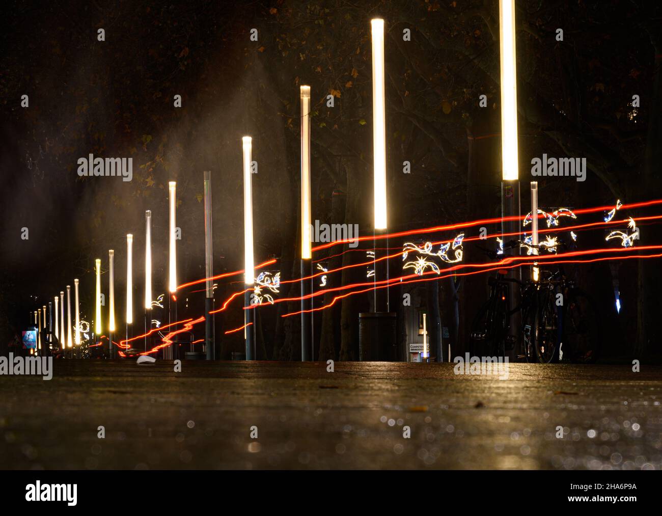 Dresde, Allemagne.09th décembre 2021.Des colonnes lumineuses éclairent la rue principale le soir, tandis que les phares des cyclistes qui passent tracent des pistes légères.Credit: Robert Michael/dpa-Zentralbild/dpa/Alay Live News Banque D'Images