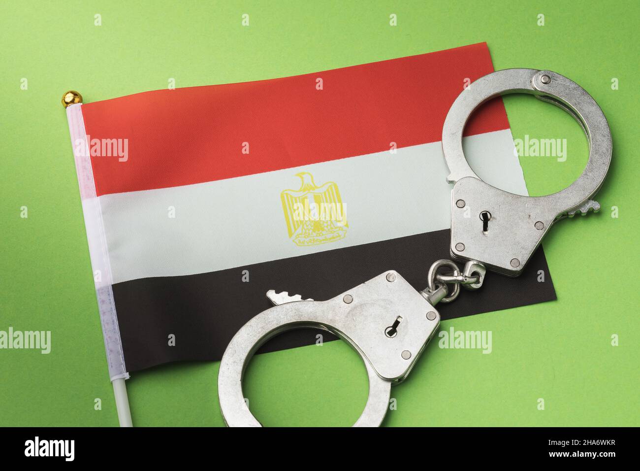 Drapeau égyptien et menottes sur fond vert, concept de crime égyptien Banque D'Images