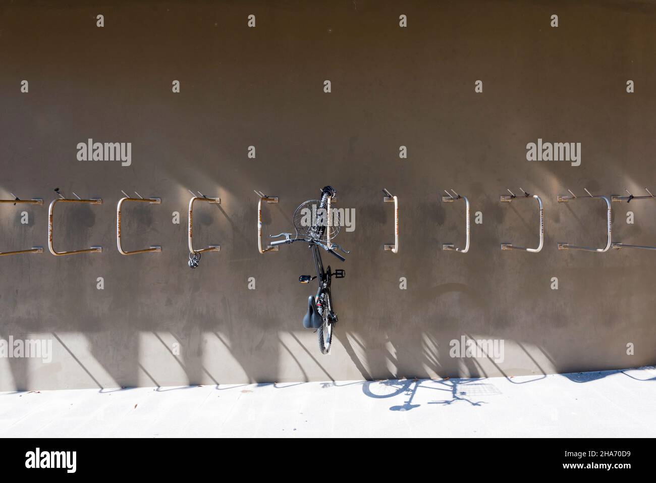 Une seule moto est suspendue à une rangée de supports muraux en acier inoxydable à l'université Macquarie, en Nouvelle-Galles du Sud, en Australie, lors d'un confinement de Covid Banque D'Images