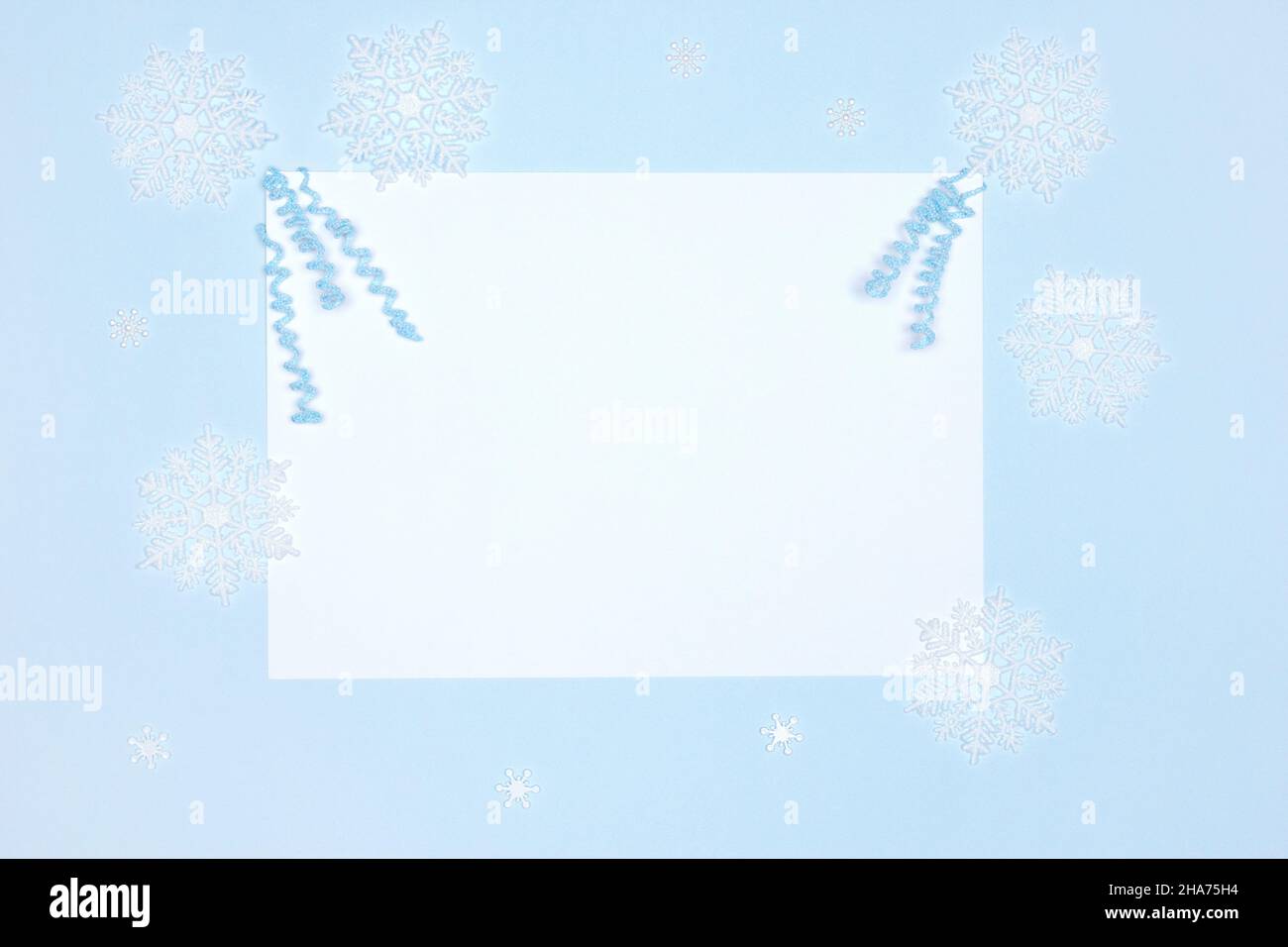 Décorations d'hiver avec carte en papier blanche vierge sur fond bleu Banque D'Images