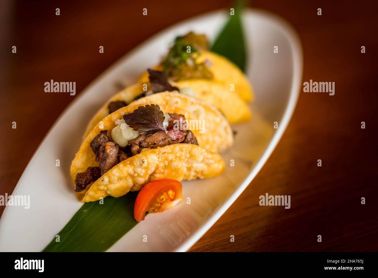 Mini-Tacos au bœuf Wagyu japonais avec Chili Ponzu sur une assiette blanche Banque D'Images