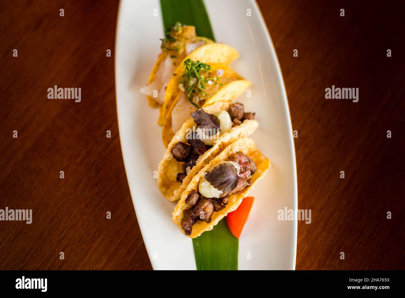 Mini-Tacos au bœuf Wagyu japonais avec Chili Ponzu sur une assiette blanche Banque D'Images