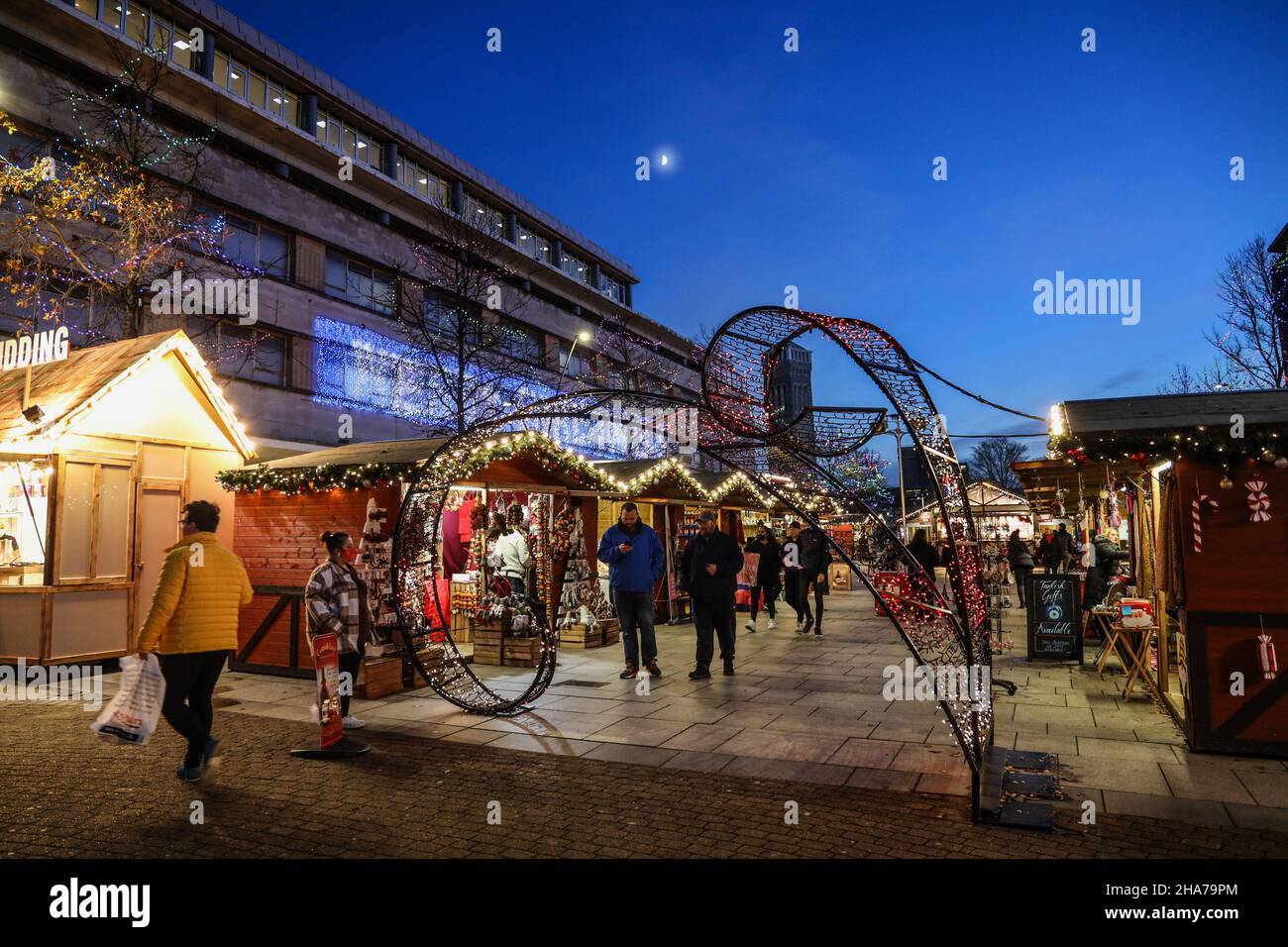 Les lumières de Noël ajoutent une chaleur aux petits stands en bois du marché de Noël de Plymouth, les masques montrent que Covid est à propos. Banque D'Images