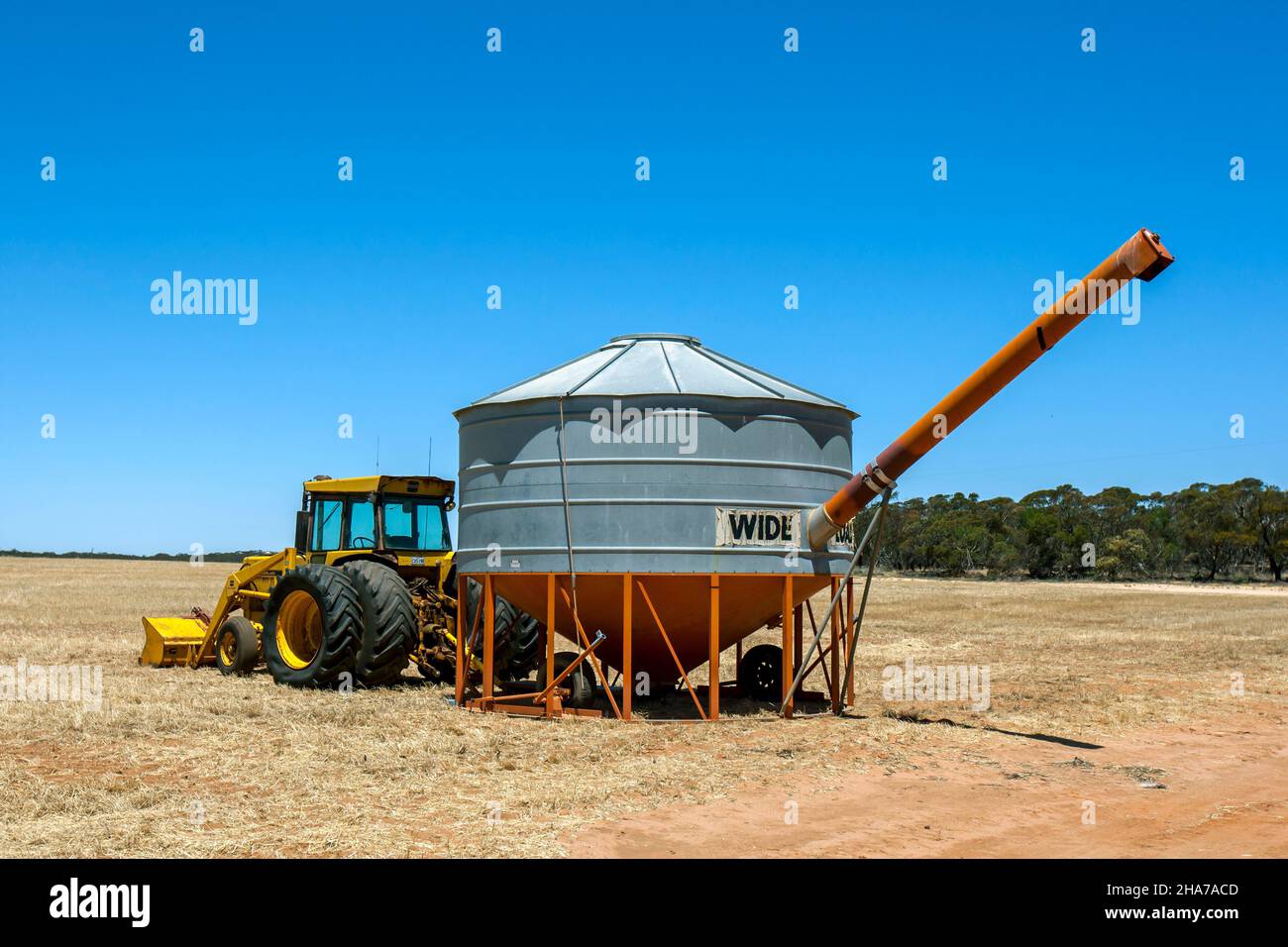 Un bac de campagne remorqué par un tracteur se trouve dans un enclos prêt à recevoir du blé récolté sur une propriété de grand hectare à Kringin, en Australie méridionale. Banque D'Images