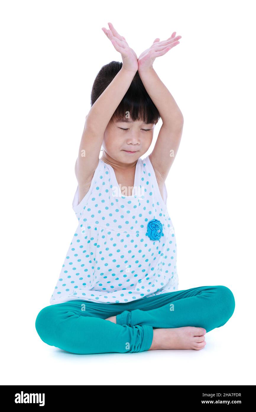 Enfant asiatique joli avec les yeux fermés et faisant des exercices de yoga dans la pose de lotus.Fille en bonne santé pratiquant la forme physique au studio.Sport et mode de vie actif.JE Banque D'Images