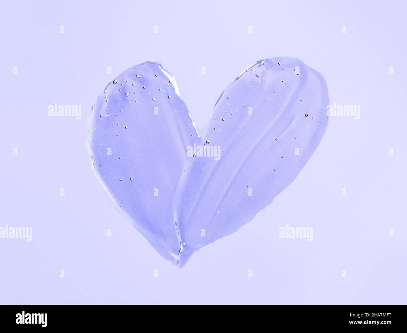 Gel liquide texture à effet de tache cosmétique en forme de coeur sur fond violet ou violet.Esthétique belle texture frottis transparent gel de peau ou masque de visage comme le coeur.Couleur de démonstration de 2022 ans très péri.Vue de dessus Banque D'Images
