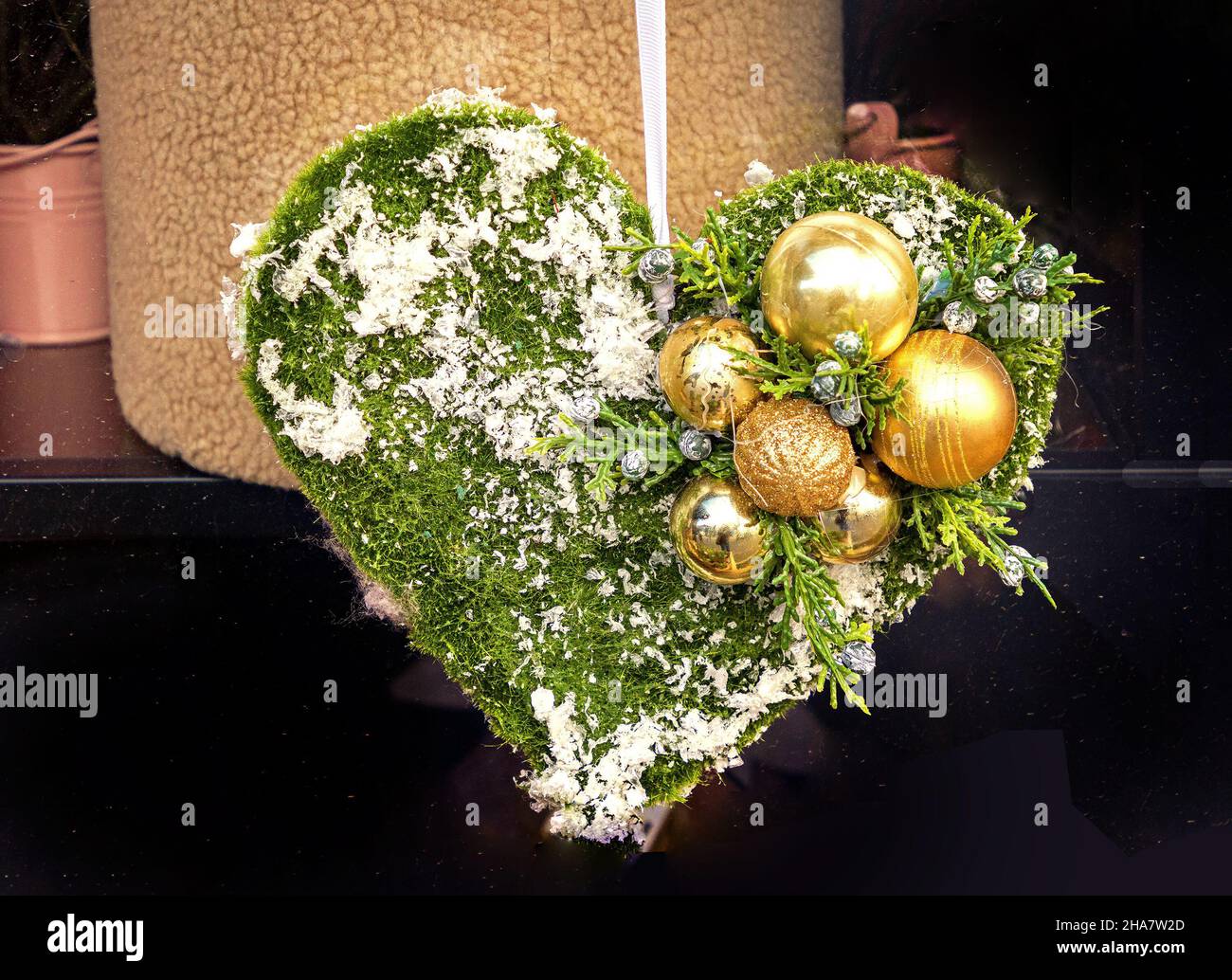 Détail de la décoration de Noël en forme de coeur ornée de bulbes dorés Banque D'Images