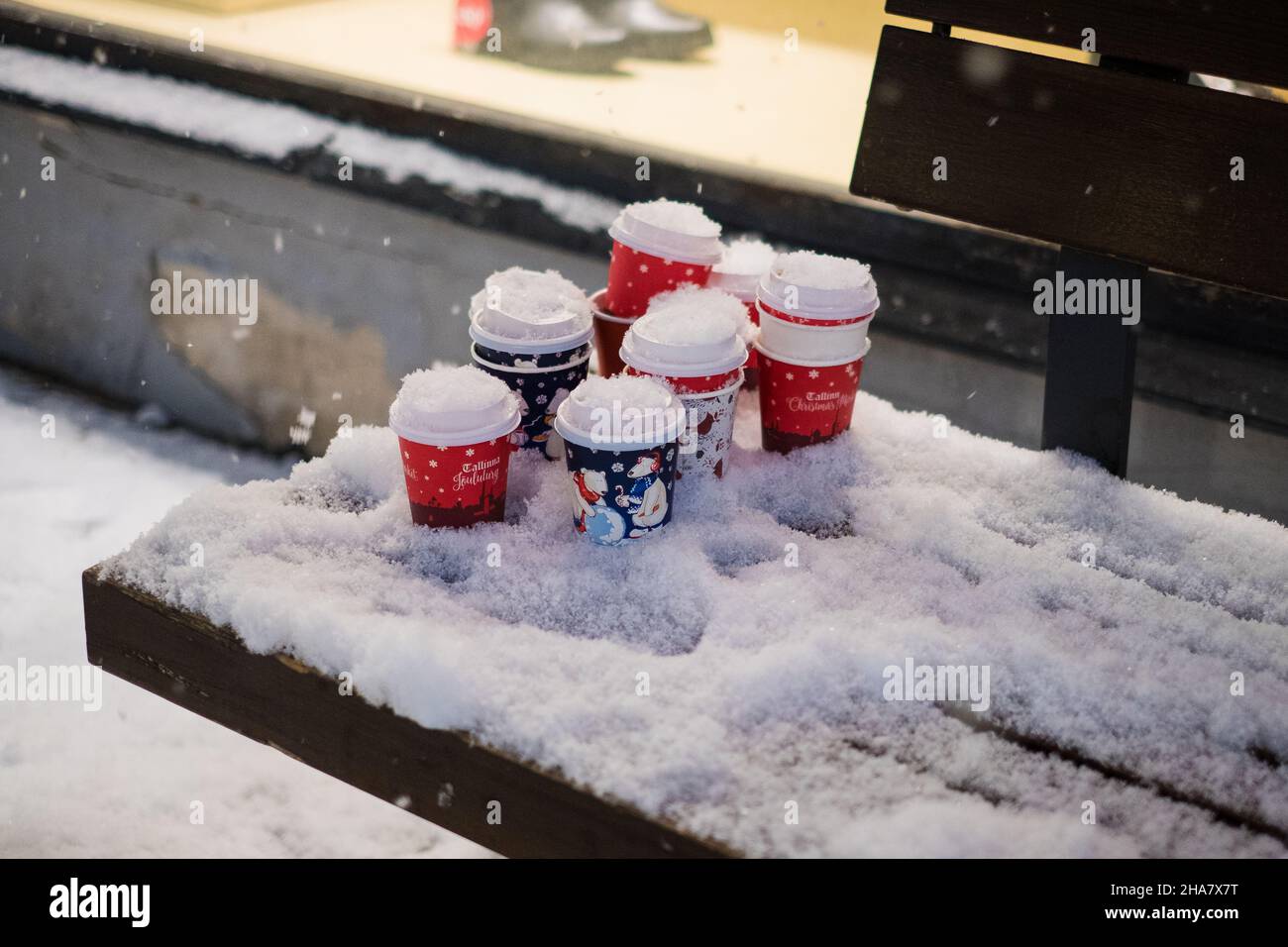 Tasses à café en papier utilisées avec motif de vacances laissées sur un banc enneigé en soirée d'hiver.Boisson chaude de Noël. Banque D'Images Tasses à café en papier utilisées avec motif de vacances laissées sur un banc enneigé en soirée d'hiver.Boisson chaude de Noël. Banque D'Images