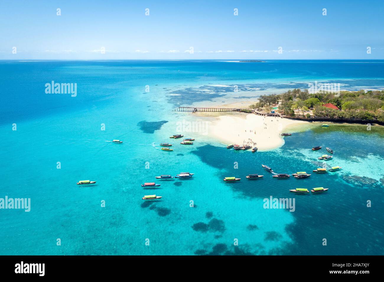 Vue aérienne de prison Island, Zanzibar, Tanzanie, près de Stone Town, avec plage et bateaux environnants.Image en tons. Banque D'Images
