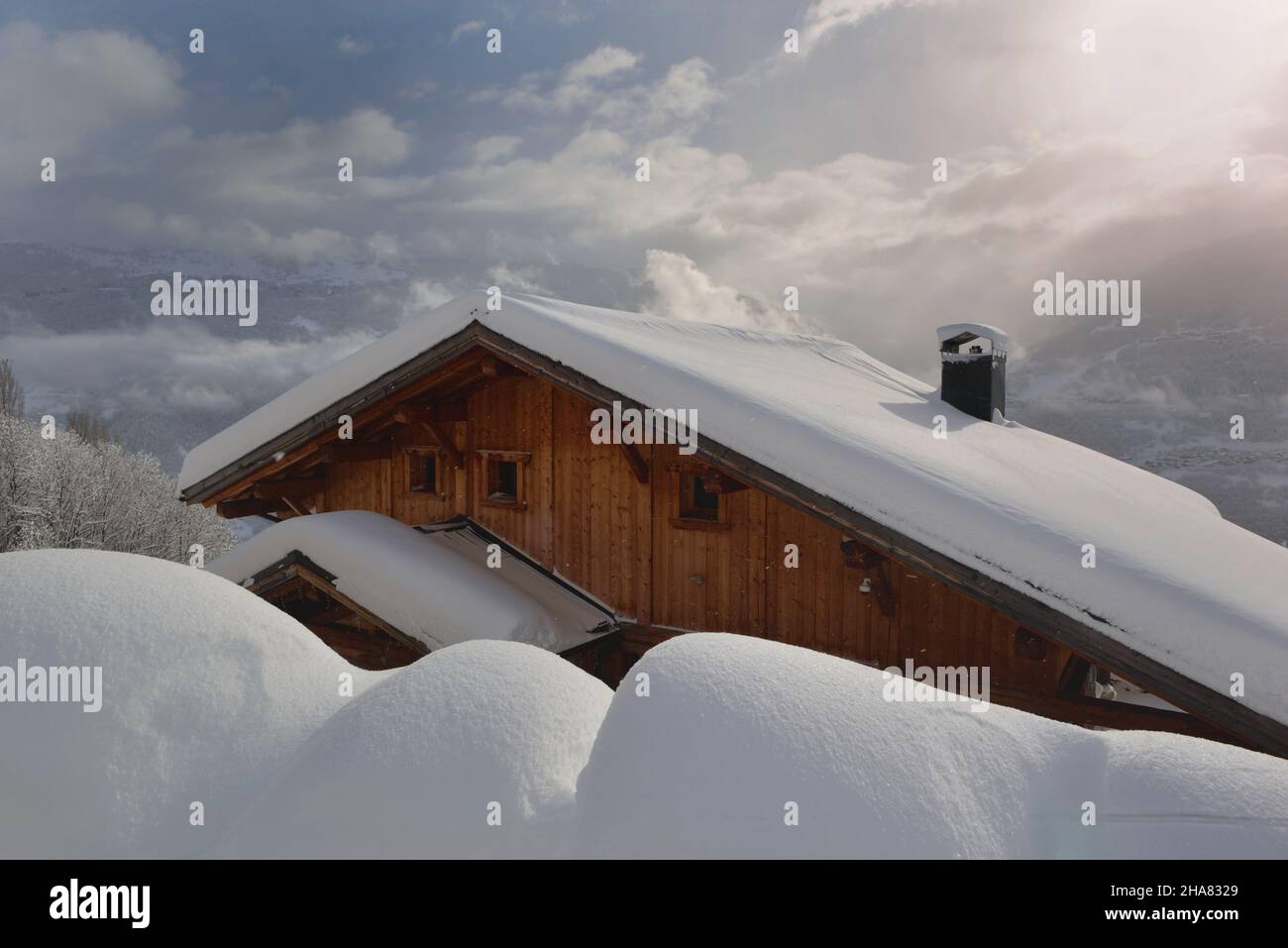 chalet en bois dans un village alpin recouvert de neige fraîche dans un paysage de montagne Banque D'Images