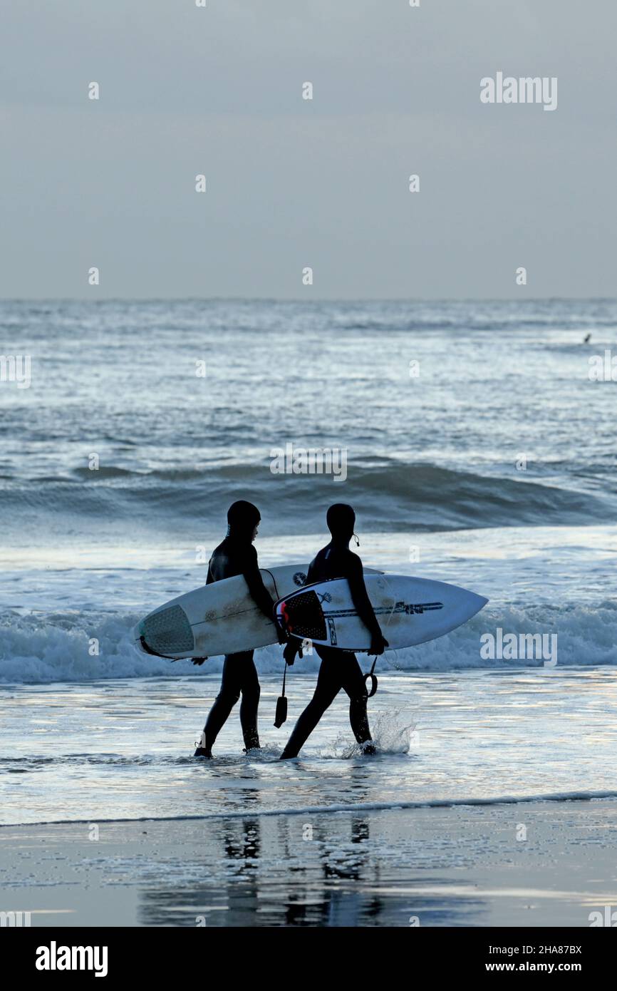 Deux jeunes surfeurs marchent au bord du surf Banque D'Images