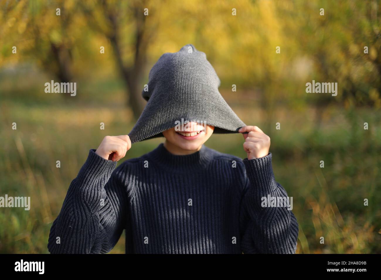 Enfant dans un chapeau dans un parc d'automne dans l'après-midi. Banque D'Images