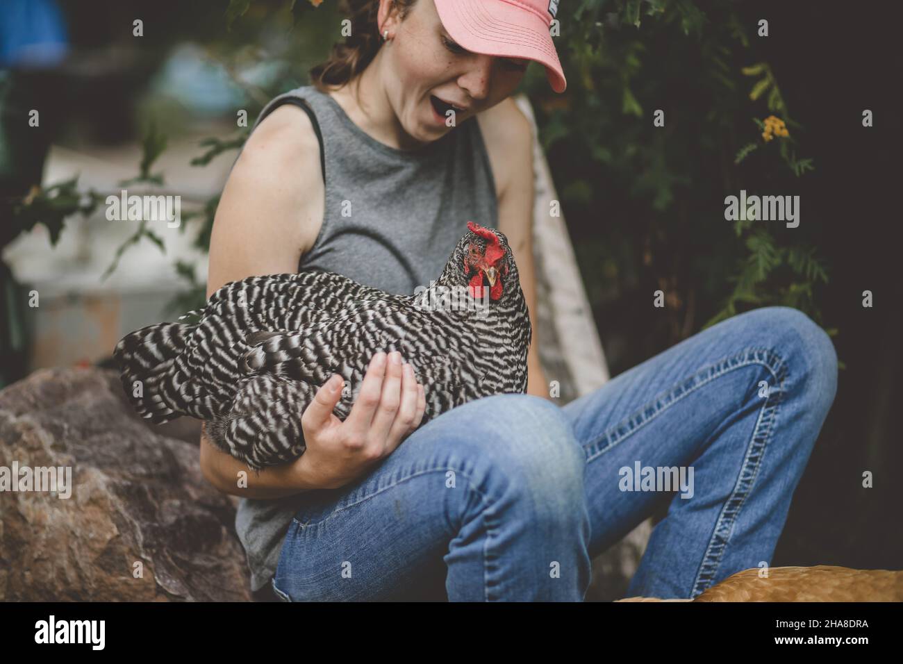 Bonne jeune fille avec du poulet sur ses genoux Banque D'Images