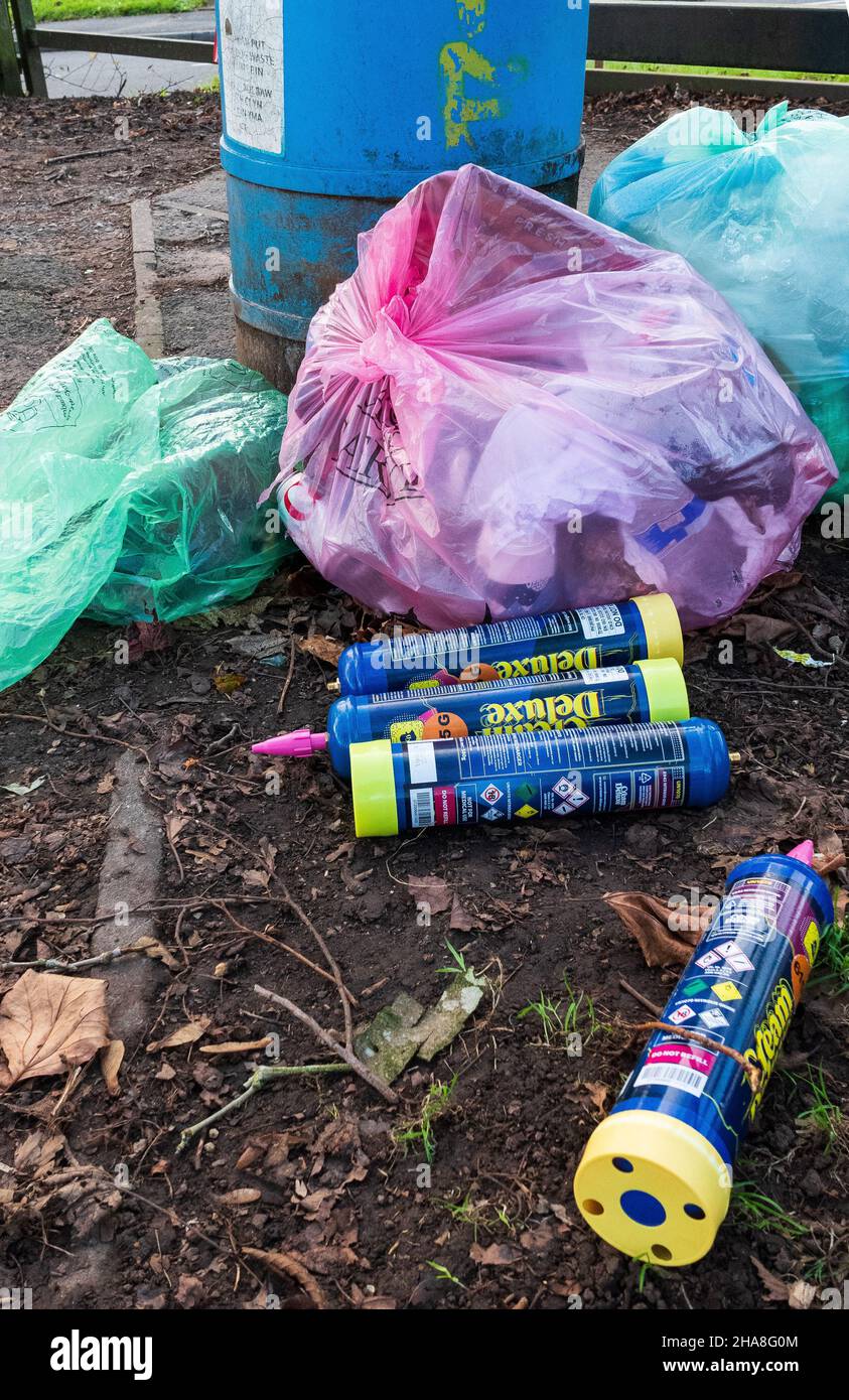 L'oxyde nitreux (gaz riant) l'abus de drogues des aérosols de crème fouettée dans un parc de la ville.Mis au rebut par le bac à déchets.Cardiff, pays de Galles Banque D'Images