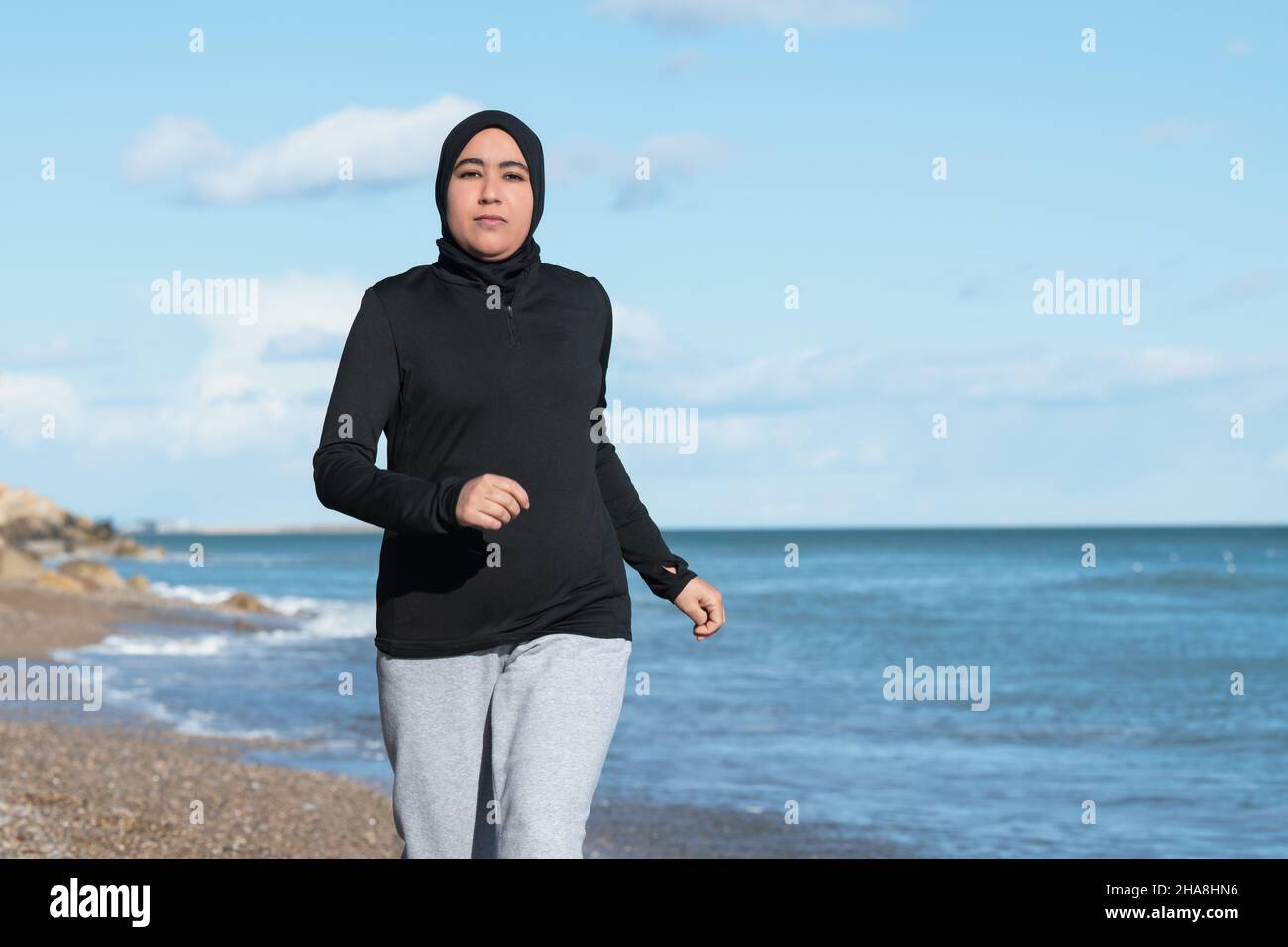 Femme arabe courant sur la plage côté mer Banque D'Images
