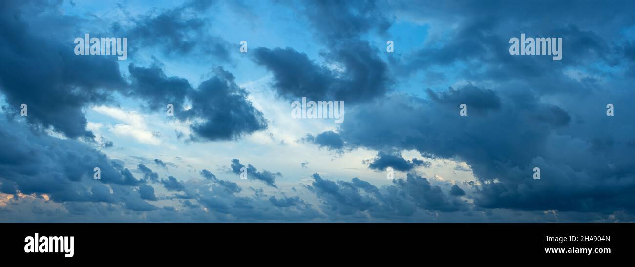 Des nuages sombres déchirés sans forme soufflés par le vent fort le soir.Paysage panoramique spectaculaire à l'heure bleue.Grand panorama du ciel couvert uniquement.Météo. Banque D'Images