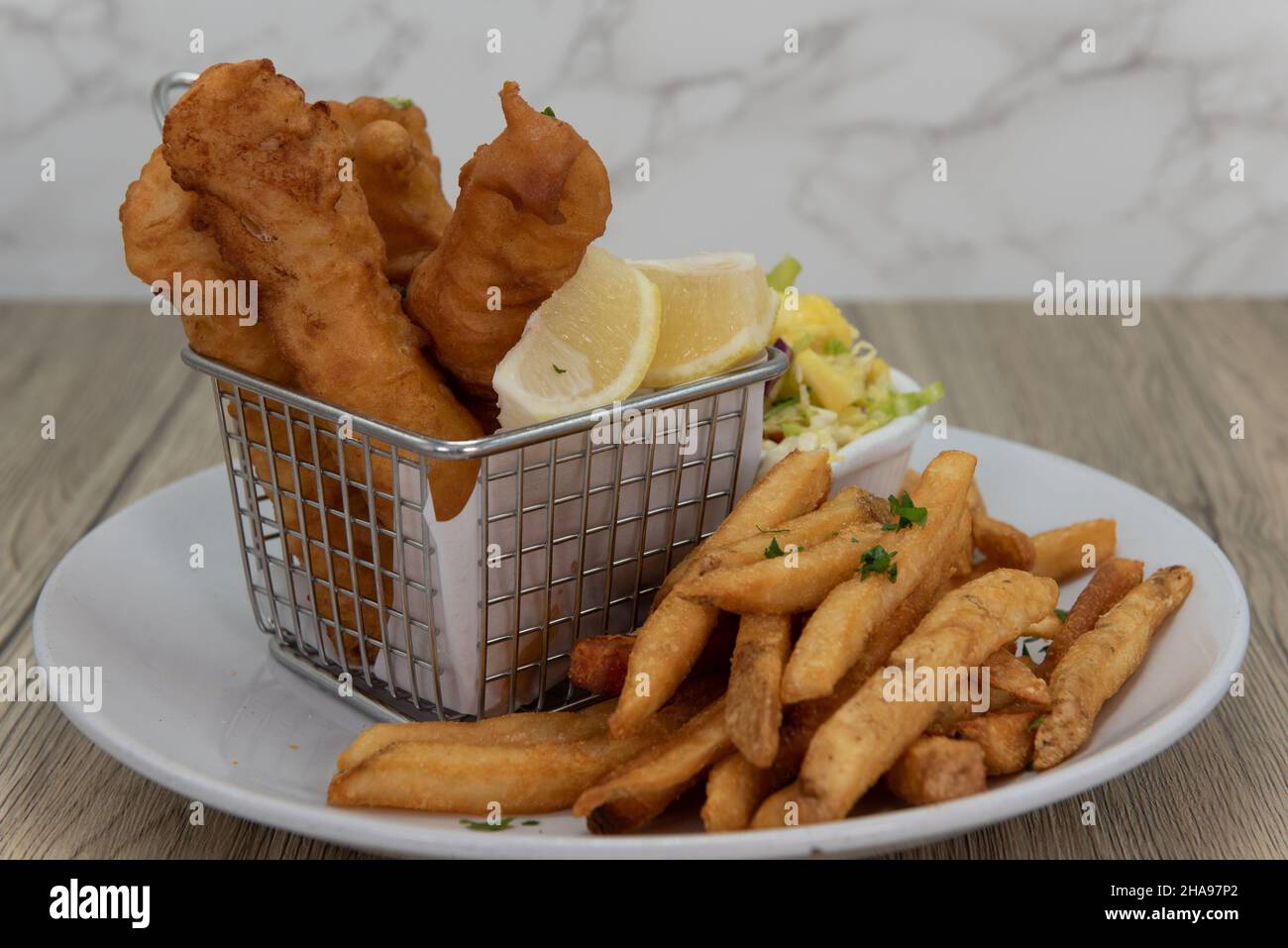 Présentation artistique de poissons frits et de frites comme un repas croquant de cuisine de fruits de mer. Banque D'Images