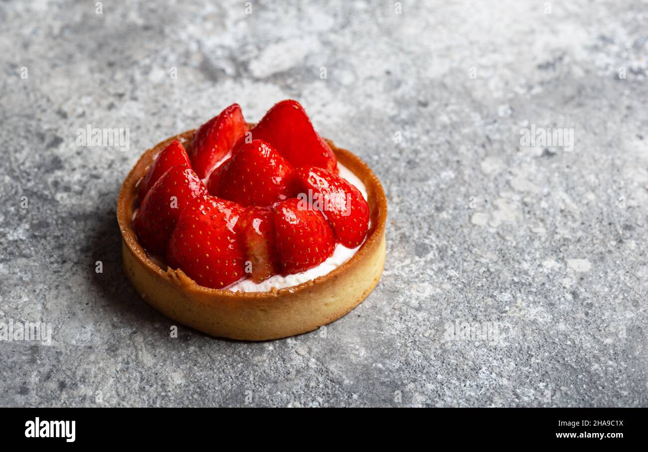 Tarte aux fraises avec crème anglaise sur fond gris gros plan Banque D'Images