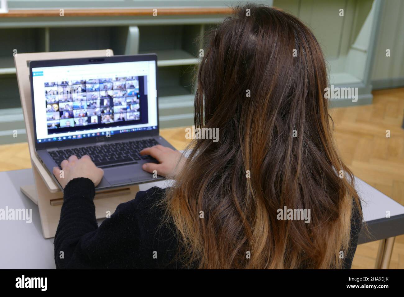 Leçon en ligne, étudiant ayant une réunion zoom. Webinaire dans une bibliothèque. Banque D'Images