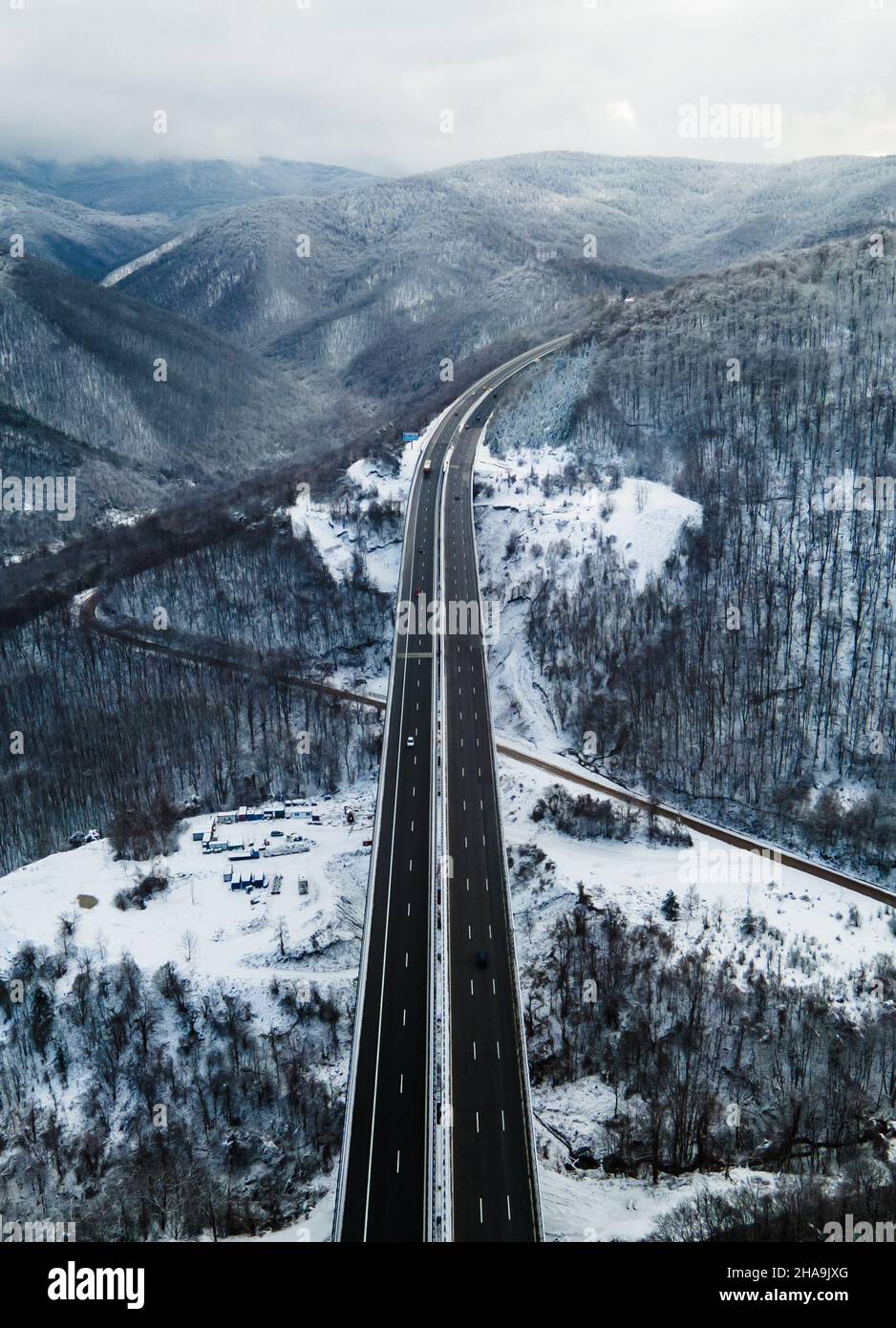 Vue aérienne incroyable sur une route.Superbe paysage de neige avec rivière et arbres.Voitures roulant sur la route.Tir de drone de neige.Photo de haute qualité Banque D'Images