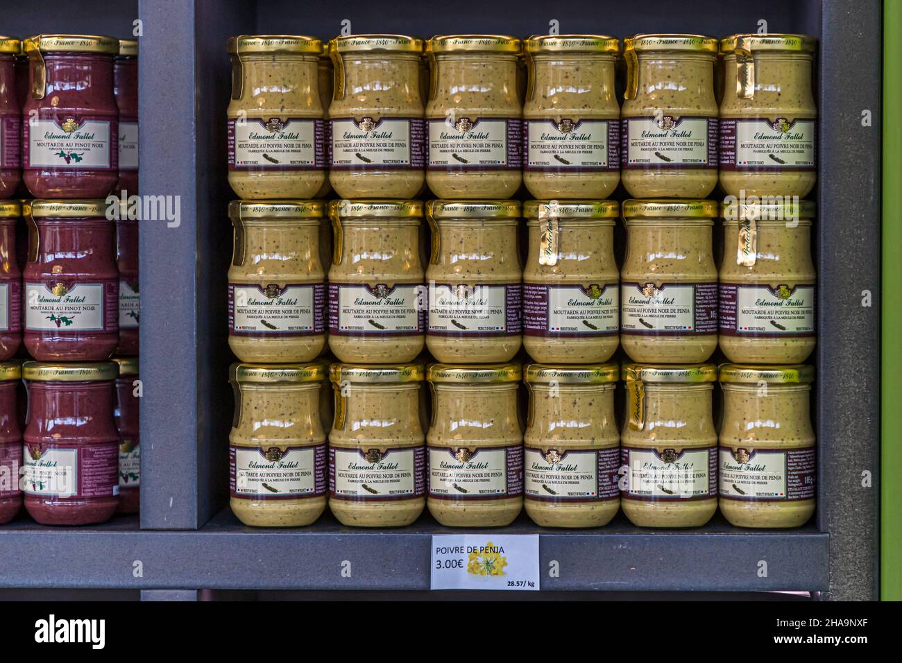 Des pots de moutarde avec du poivre Penja de la ligne Moutarderie Edmond Fallot garnissent l'étagère à Beaune, en Bourgogne, France. Le prix indiqué est de 3 euros par pot. Le poivre Penja du Cameroun bénéficie d'une indication géographique protégée (IGP) et est considéré internationalement comme particulièrement fin. Banque D'Images
