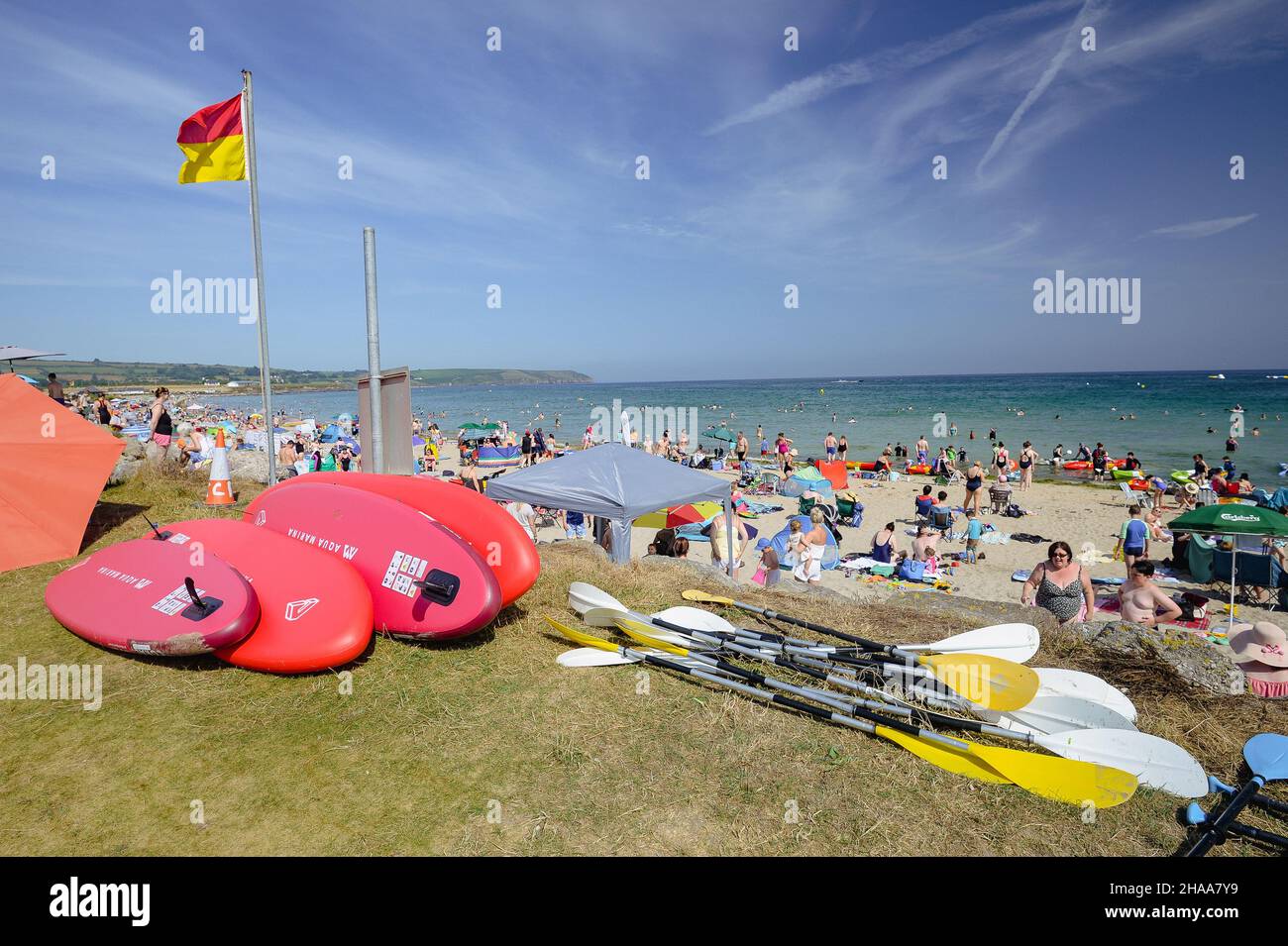 En juillet, levez-vous pour pagayer sur les planches et pagaies à côté d'une plage bondée à Clonea Strand, Waterford, Irlande. Banque D'Images