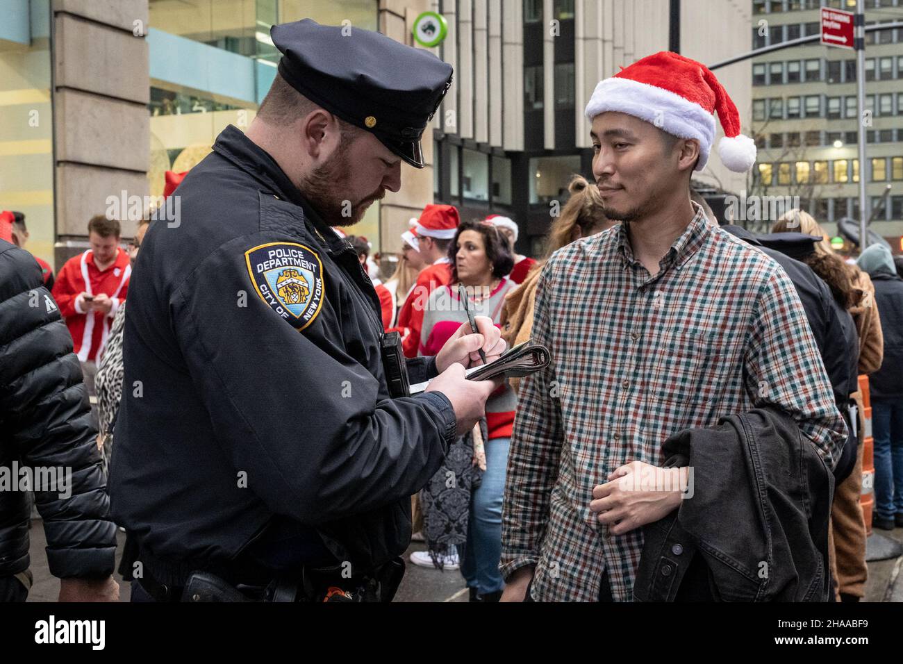 New York, États-Unis.11th décembre 2021.Les agents de la NYPD délivrent des convoqués pour la consommation d'alcool en public aux participants de Santa con à New York, NY, le 11 décembre 2021.(Photo de Gabriele Holtermann/Sipa USA) crédit: SIPA USA/Alay Live News Banque D'Images