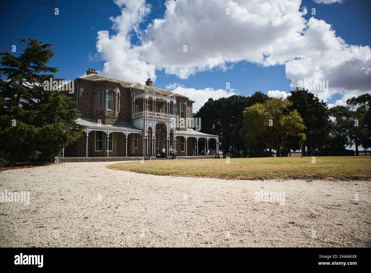 Photo légèrement inclinée de Barwon Park Mansion avec quelques personnes en face Banque D'Images