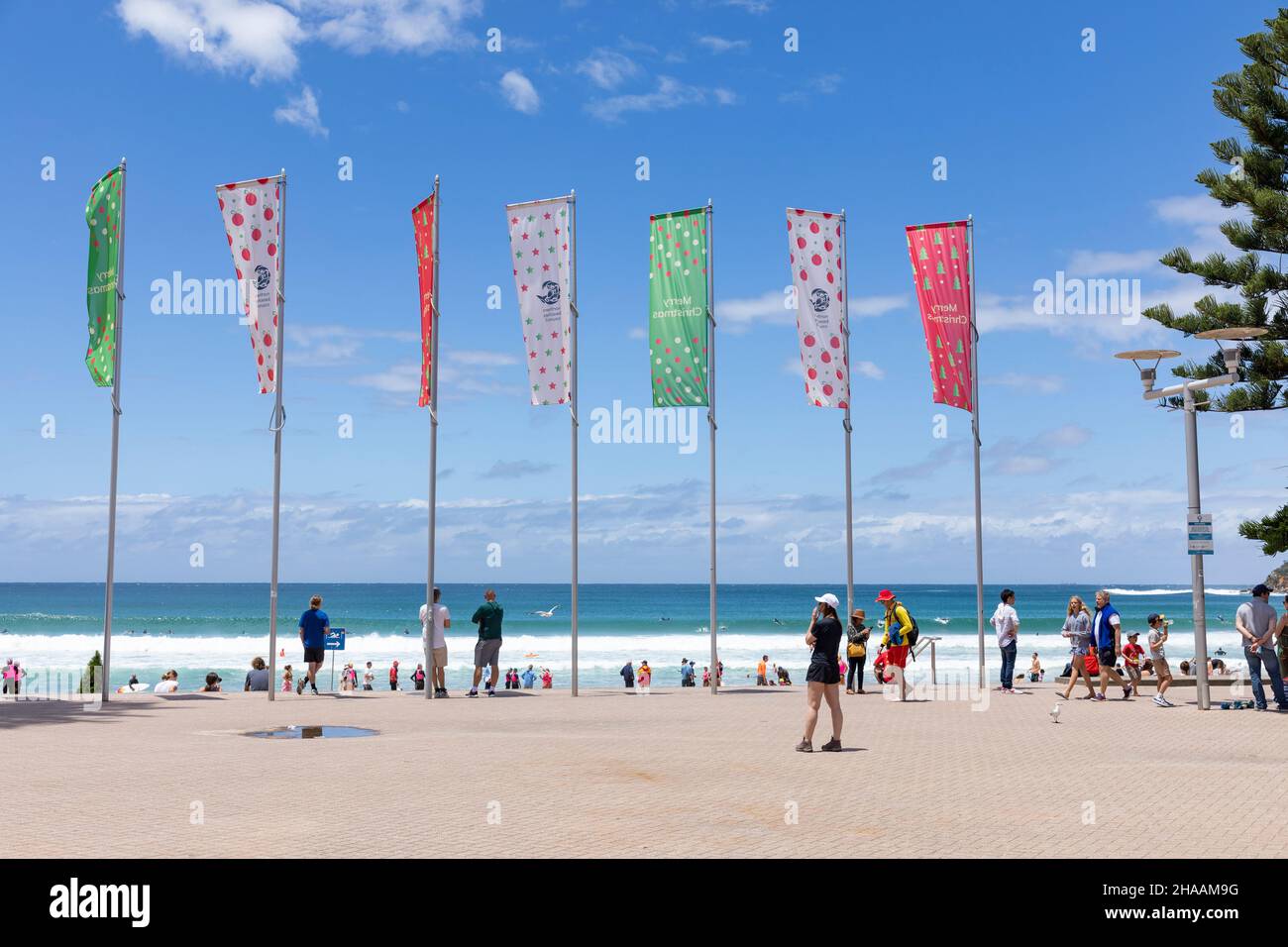 Joyeux Noël et joyeux bannières érigées sur la promenade de Manly Beach à Sydney, ciel bleu le jour d'été, Sydney, Australie Banque D'Images