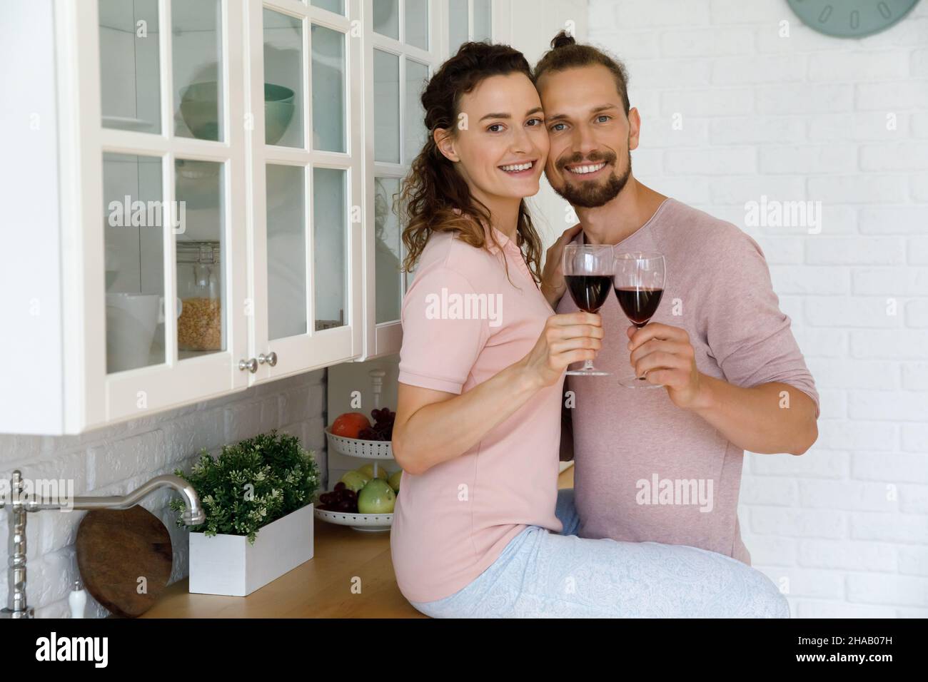 Couple millénaire heureux, jeune mari et femme buvant du vin rouge Banque D'Images
