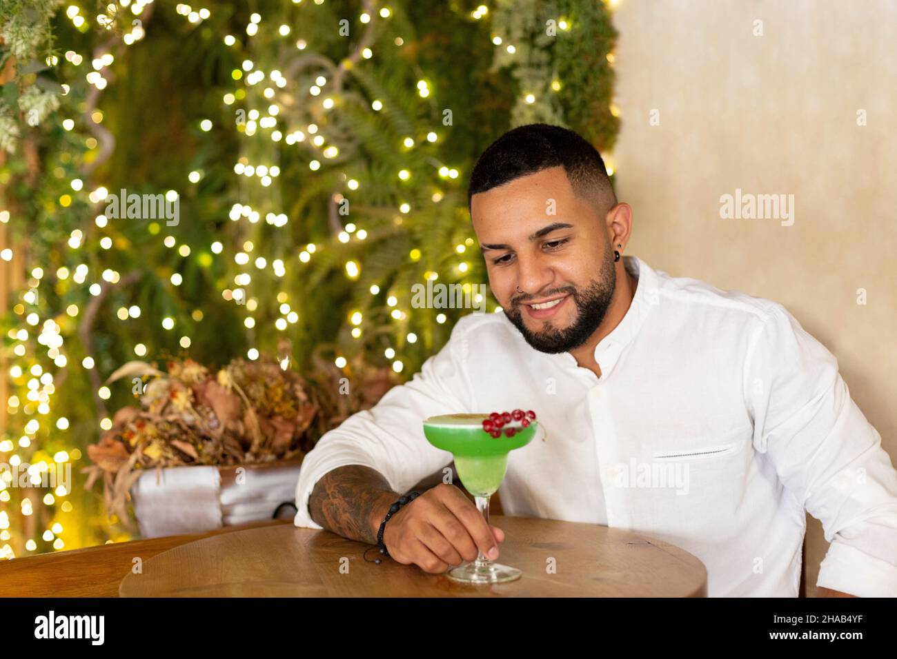 Un homme latino-américain boit une boisson alcoolisée exotique dans un élégant bar.Espace pour le texte. Banque D'Images