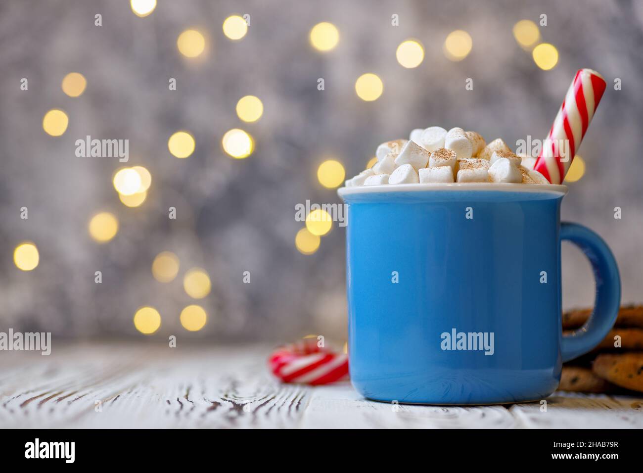 Chocolat chaud ou cacao avec guimauve et canne à sucre dans une tasse en céramique Banque D'Images