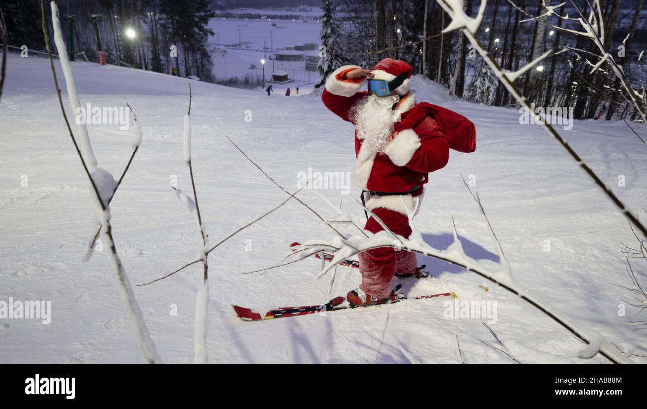 Santa Claus skieur alpin dans la forêt enneigée station de ski pente Noël sport fête de style de vie Banque D'Images
