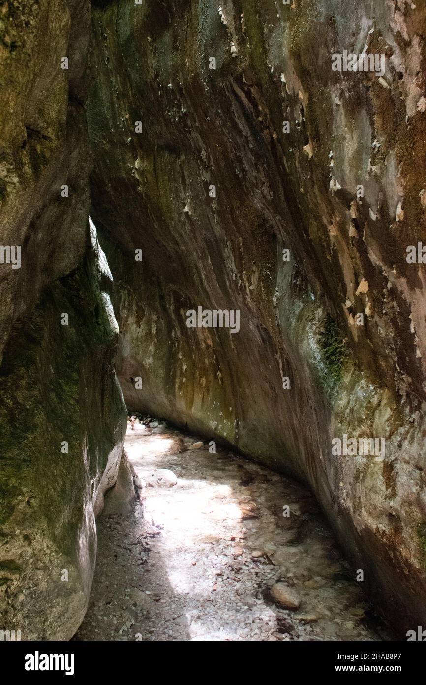 Vue à l'intérieur de la grotte avec des rayons de lumière et de petites pierres dans une eau peu profonde Banque D'Images