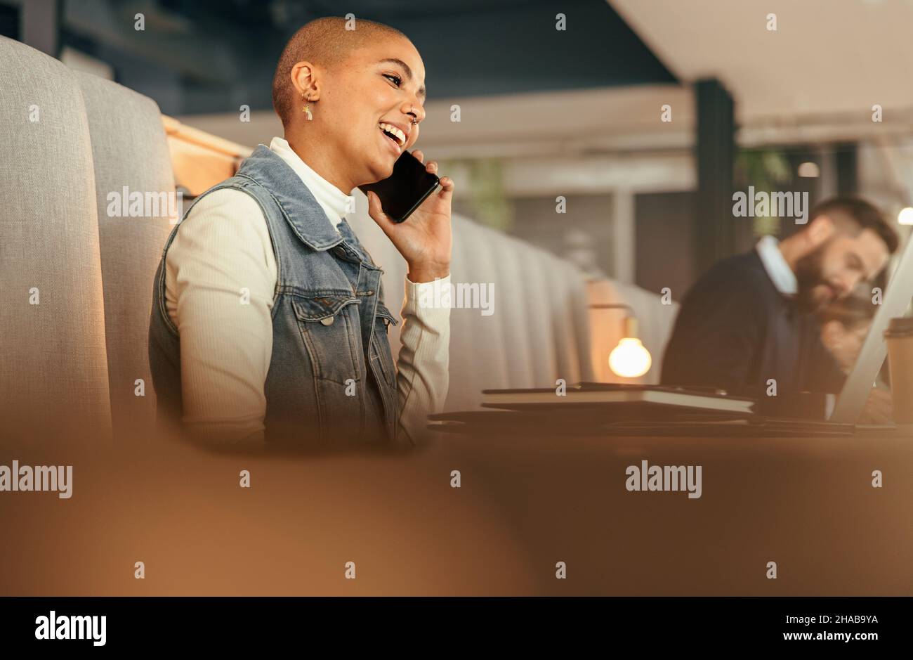 Femme d'affaires du millénaire parlant au téléphone dans un espace de travail conjoint.Une jeune femme d'affaires heureuse communique avec ses collaborateurs lors d'un appel téléphonique.FEM Banque D'Images
