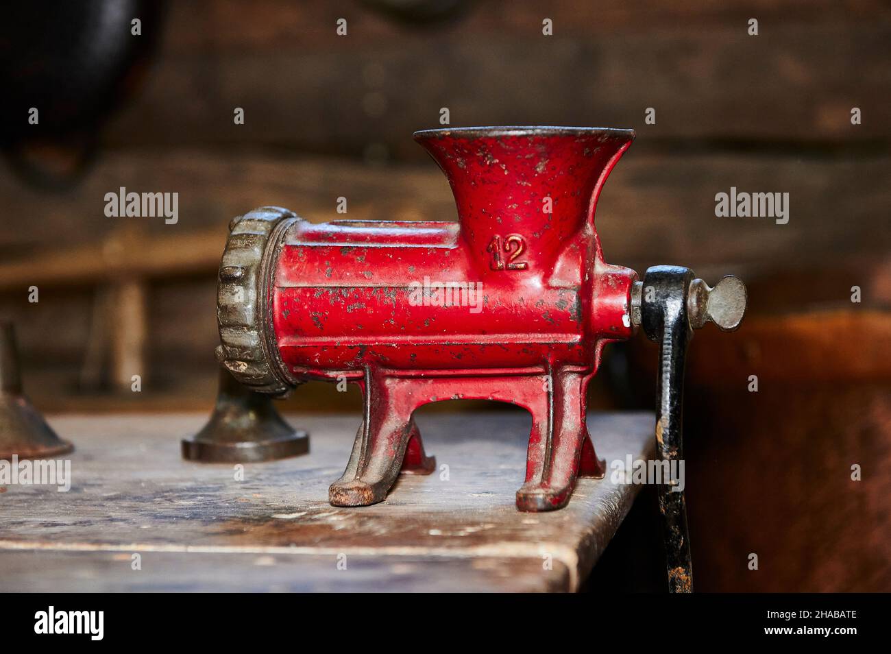 ancienne machine à hacher rouge isolée sur une table en bois Banque D'Images