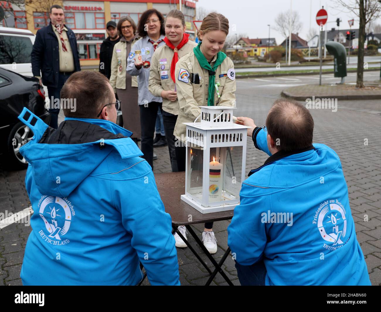 Magdebourg, Allemagne.12th décembre 2021.Scouts Torgen (l.) et Timo de Brême,Distribuer la lumière de la paix à scout Hanna de Badersleben à un arrêt de repos sur le A2.plus de 150 scouts ont mis un signe pour le dialogue interreligieux sous la devise de cette année de la lumière de la paix 'réseau de la paix - une lumière qui relie tous'.en raison de la situation actuelle de Covid,tous les scouts doivent respecter les règles d'hygiène applicables.Credit: Peter Gercke/dpa-Zentralbild/dpa/Alay Live News Banque D'Images