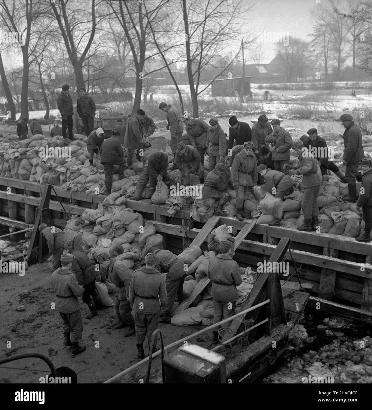 Lubczyna, 1969-12.Niekorzystne warunki atmosferyczne spowodowa³y spiêtrzenie wód jeziora D¹bie, które przerwa³y W okolicy Lubczyny wa³ przeciwpowodziowy i zala³y teren o powierzchni 1000 ha.NZ. Budowa wa³u przeciwpowodziowego. kw PAP/Andrzej Witusz Dok³adny dzieñ wydarzenia nieustalony.Lubczyna, décembre 1969.Les conditions météorologiques inconfortables ont entraîné des déversements dans les eaux du lac Dabie.L'eau a brisé un barrage près de Lubczyna et a inondé la superficie de 1000 hectares.Photo : des soldats et des bénévoles construisent un barrage temporaire. kw PAP/Andrzej Witusz Banque D'Images