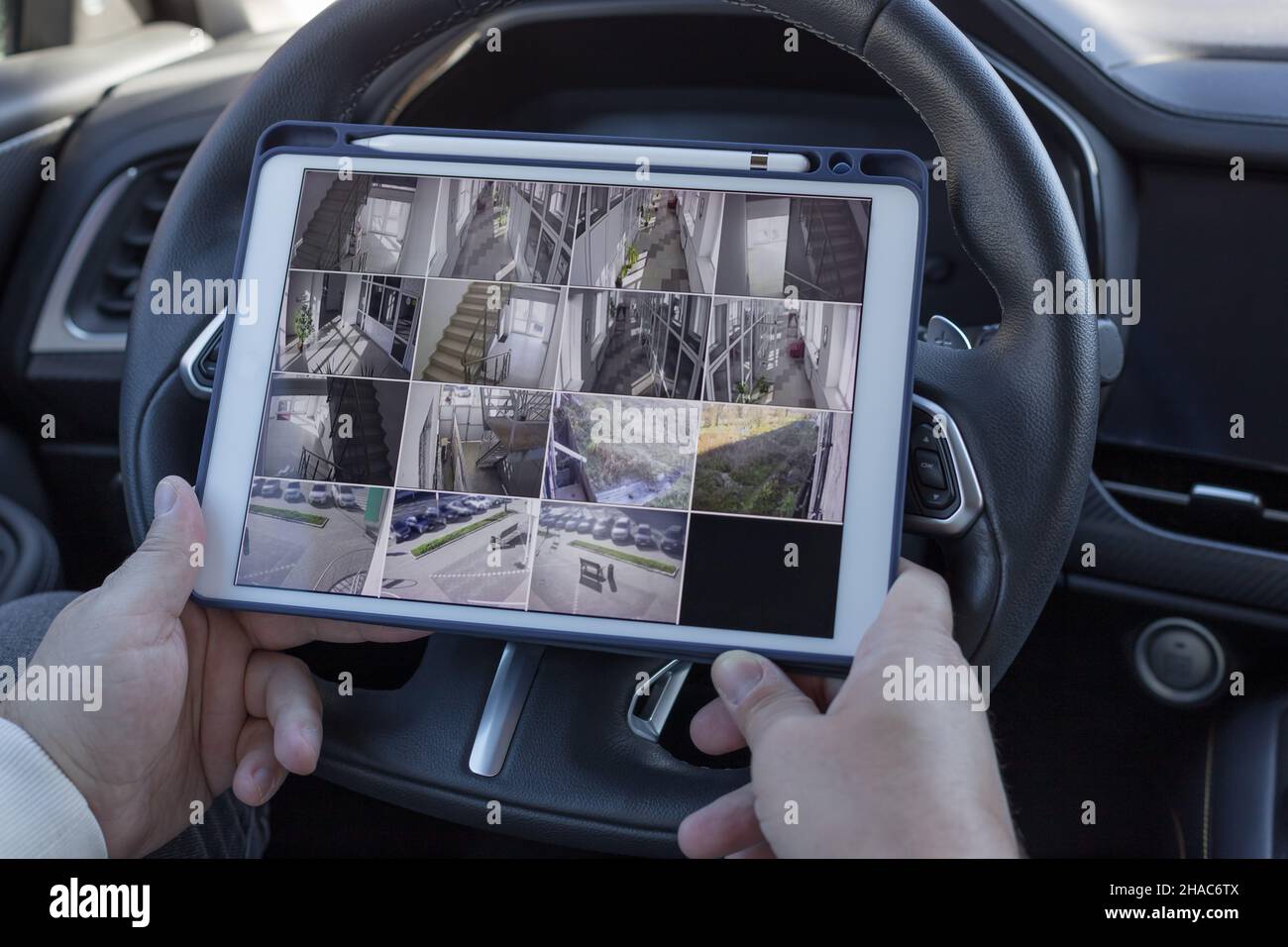Homme utilisant une tablette numérique pour surveiller des caméras de vidéosurveillance Banque D'Images